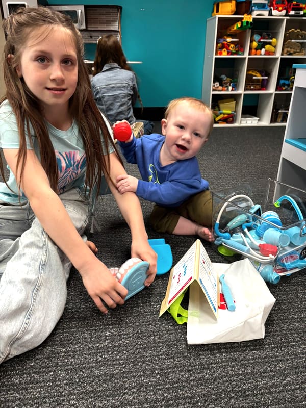 An Anchor Homeschool Co-op student playing doctor with her little brother