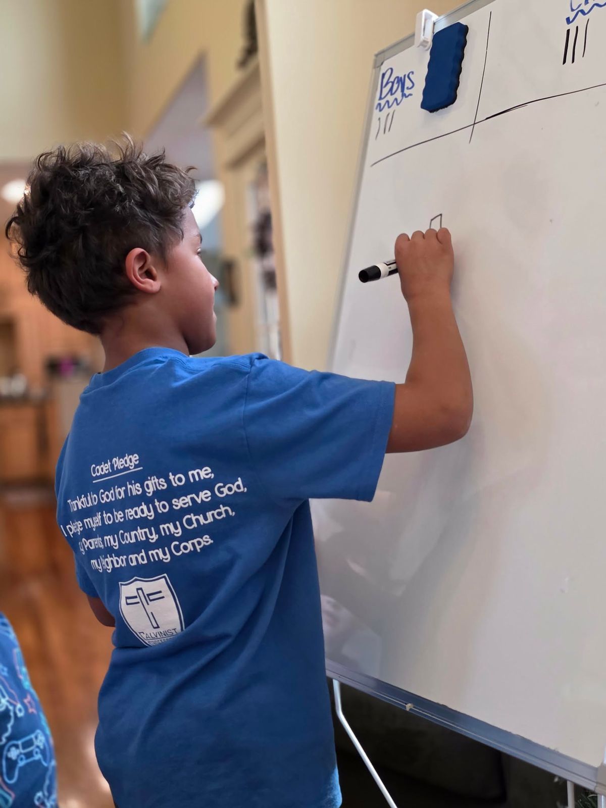 Homeschool student drawing on a whiteboard during class at Anchor Christian Homeschool Co-op